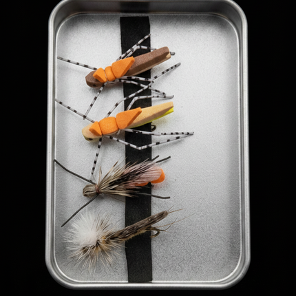 Set of fly fishing flies on a metal tray with a black and white striped background