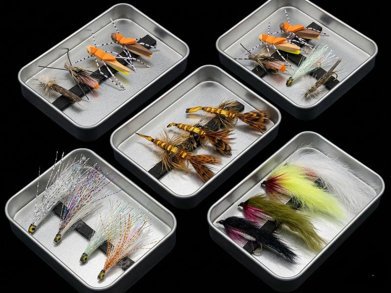 Set of fishing lures in small metal trays on a black background