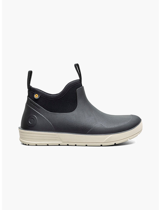 A single waterproof ankle boot in dark gray and black with a cream-colored sole, shown in a side profile on a light gray background. The brand name 'BOGS' is visible on the heel.