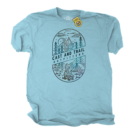 Light blue t-shirt with a graphic of mountains, trees, a tent, and a campfire with words Cast and Trail Outfitters.