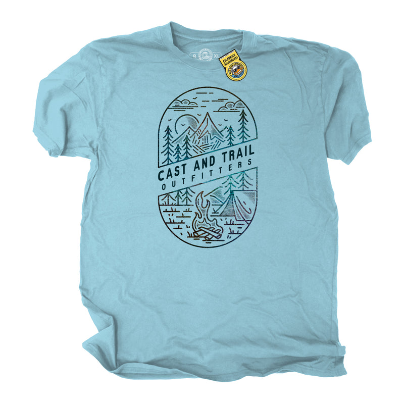 Light blue t-shirt with a graphic of mountains, trees, a tent, and a campfire with words Cast and Trail Outfitters.