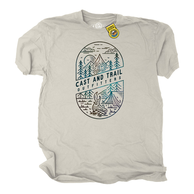 Beige t-shirt with outdoor graphic design of a forest, fire, tent, moon, campsite, and 'Cast and Trail Outfitters' text on a white background