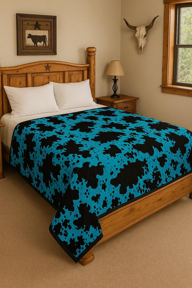 Bedroom with wooden bed, blue and black patterned blanket, and cow skull decor.