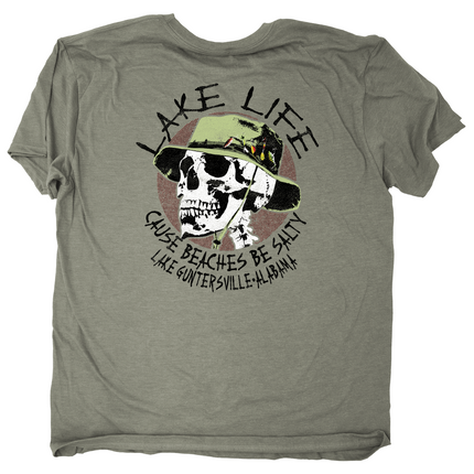 An olive green short-sleeve t-shirt with a graphic print on the front. The graphic features a skull wearing a green hat, surrounded by the text 'LAKE LIFE CAUSE BEACHES BE SALTY' and 'LAKE GUNTERSVILLE, ALABAMA'.