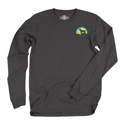 Dark grey long sleeve t-shirt with a graphic of a dog on a hill in front of a yellow and blue sunset with words Cast and Trail Outfitters.