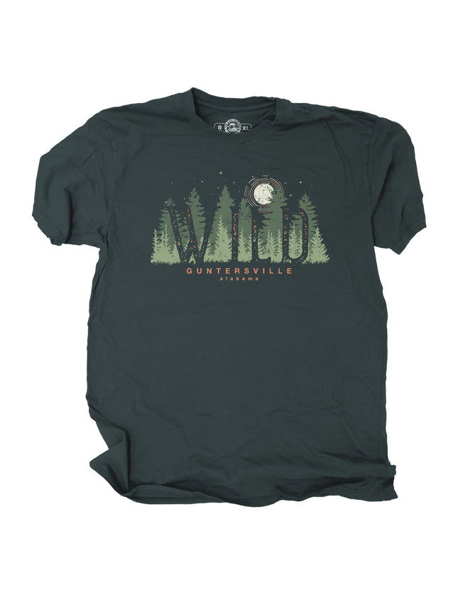 Dark green t-shirt with forest graphic, wild in text, and text stating Guntersville Alabama on a white background