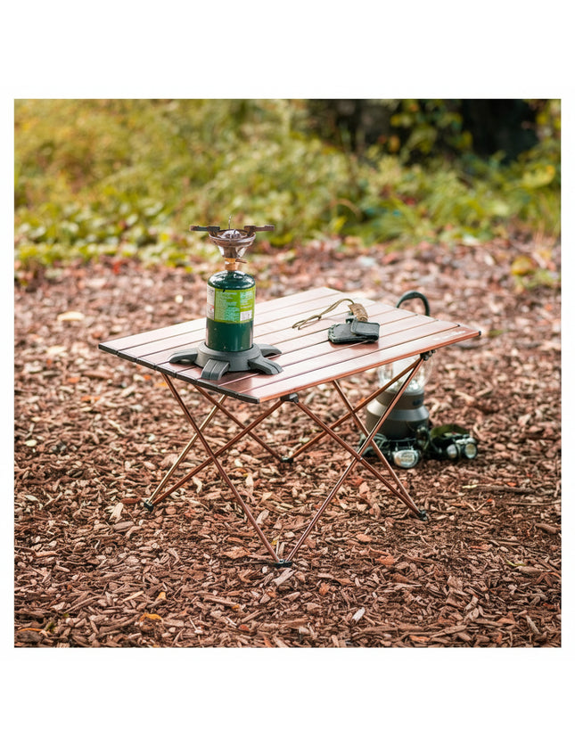 Small wooden camping table with a portable stove and other items on a natural outdoor background