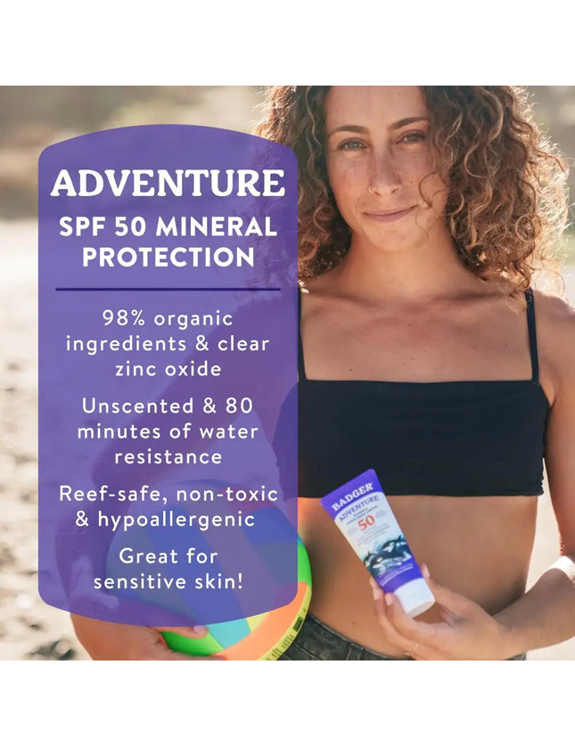 Woman holding Badger Adventure SPF 50 Mineral Protection sunscreen and a beach ball