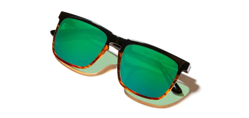 Black frame sunglasses with green reflective lenses and tortoise shell accents