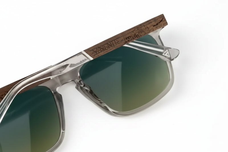 Close up of sunglasses with clear frames and dark wooden arms