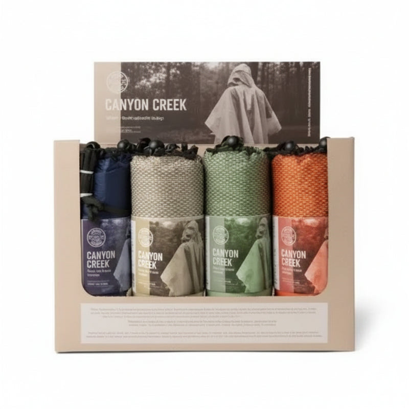 Canyon Creek poncho display box with four rolled ponchos in blue, tan, green, and orange