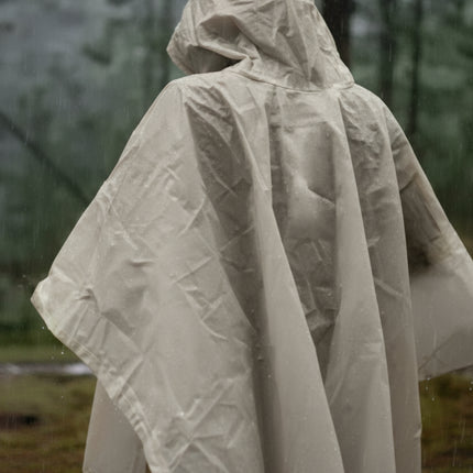 Person wearing a hooded beige poncho in a forest
