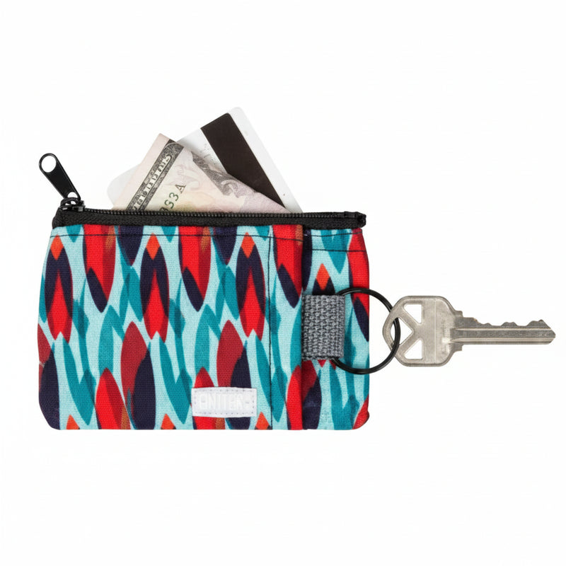 Small patterned pouch with zipper, containing cards and cash, with a key attached to a ring