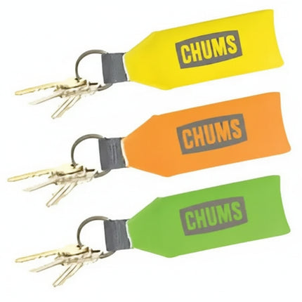 Three Chums brand floating keychains in yellow, orange, and green, each with keys attached