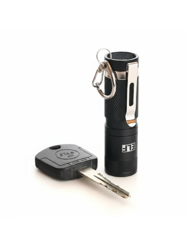 Black ELF flashlight with a silver clip and a car key
