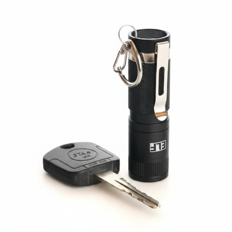 Black ELF flashlight with a silver clip and a car key
