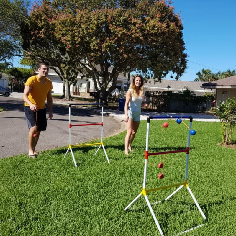Two people playing ladder toss on a sunny lawn with trees and houses in the background