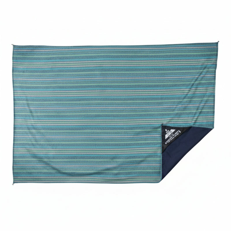 Blue and green striped beach blanket with a small black triangular logo in the bottom right corner
