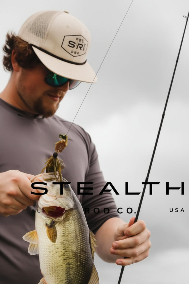 A man wearing a beige cap and sunglasses holds a largemouth bass while holding a fishing rod. The image features a dark gray overlay with the text 'STEALTH CO.