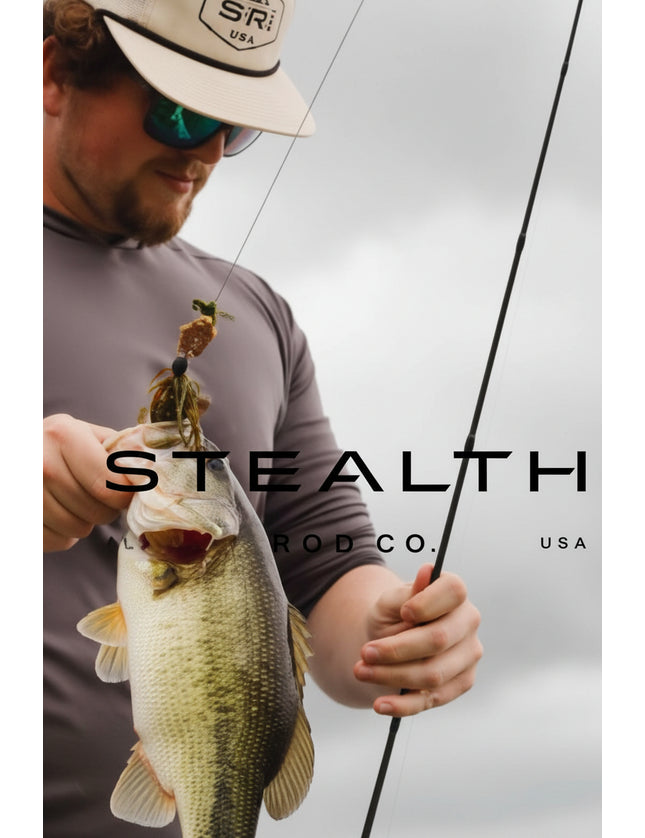 A man wearing a beige cap and sunglasses holds a largemouth bass while holding a fishing rod. The image features a dark gray overlay with the text 'STEALTH CO.