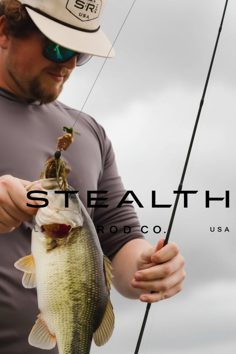 A man wearing a beige cap and sunglasses holds a largemouth bass while holding a fishing rod. The image features a dark gray overlay with the text 'STEALTH CO.