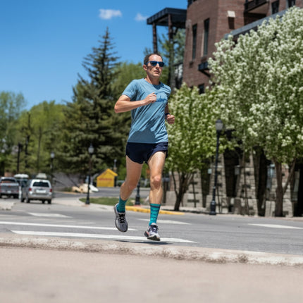 Man in blue shirt and black shorts running on a street