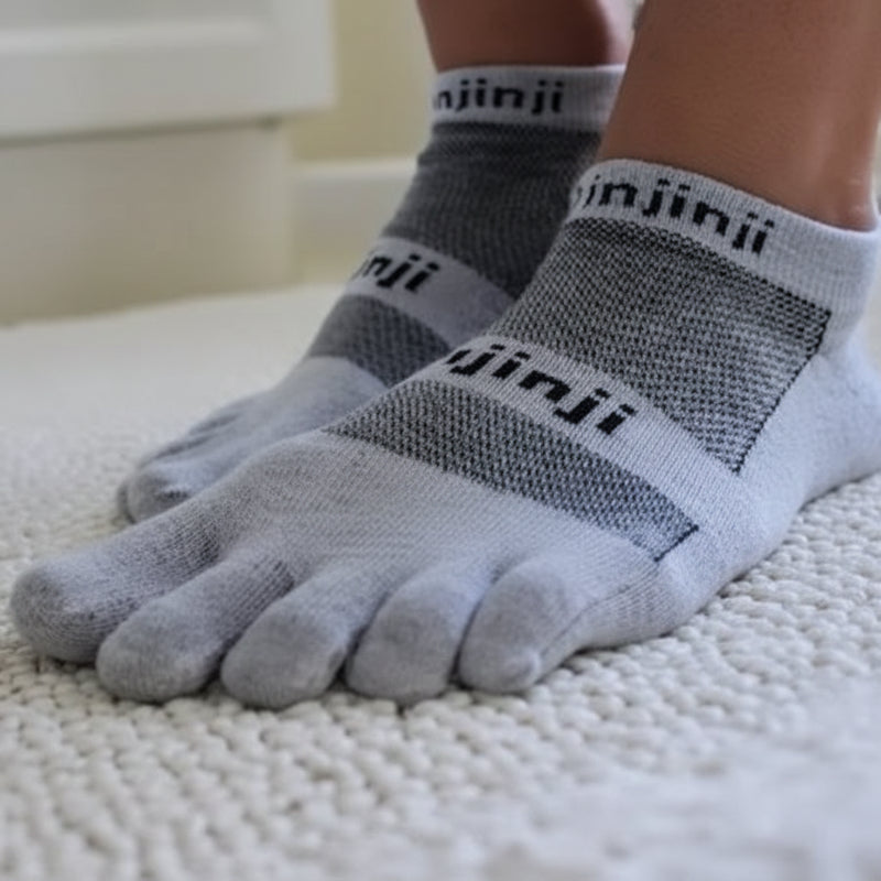 Pair of grey Injinji toe socks on a person's feet