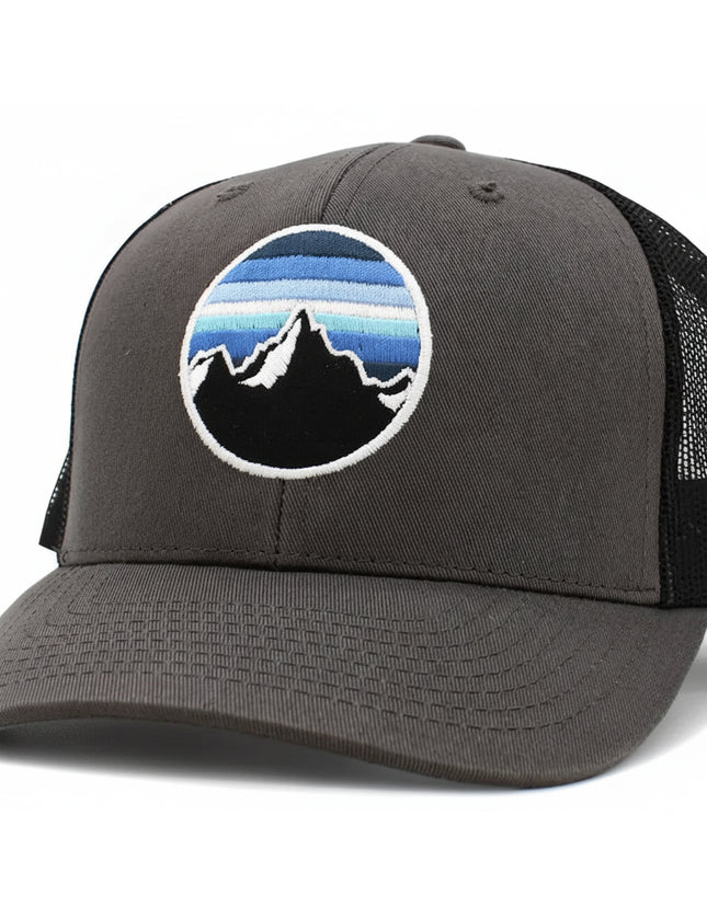 Grey trucker hat with a circular patch featuring black mountains and blue sky stripes