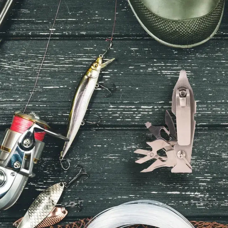 Fishing gear including a reel, lures, and a multi-tool on a dark wooden surface