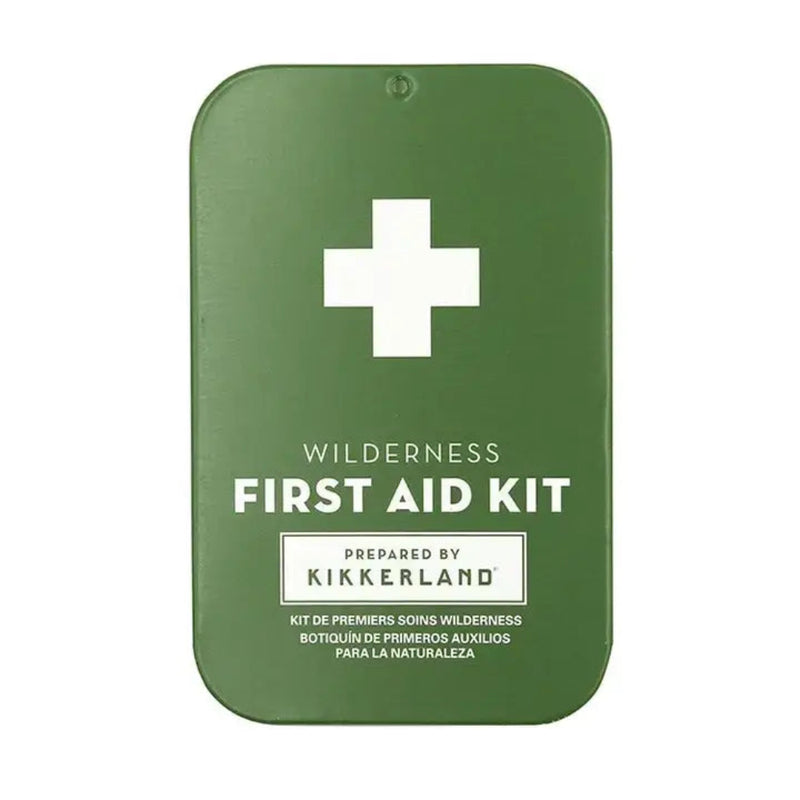 Green first aid kit with a white cross and text Wilderness First Aid Kit Prepared by Kikkerland