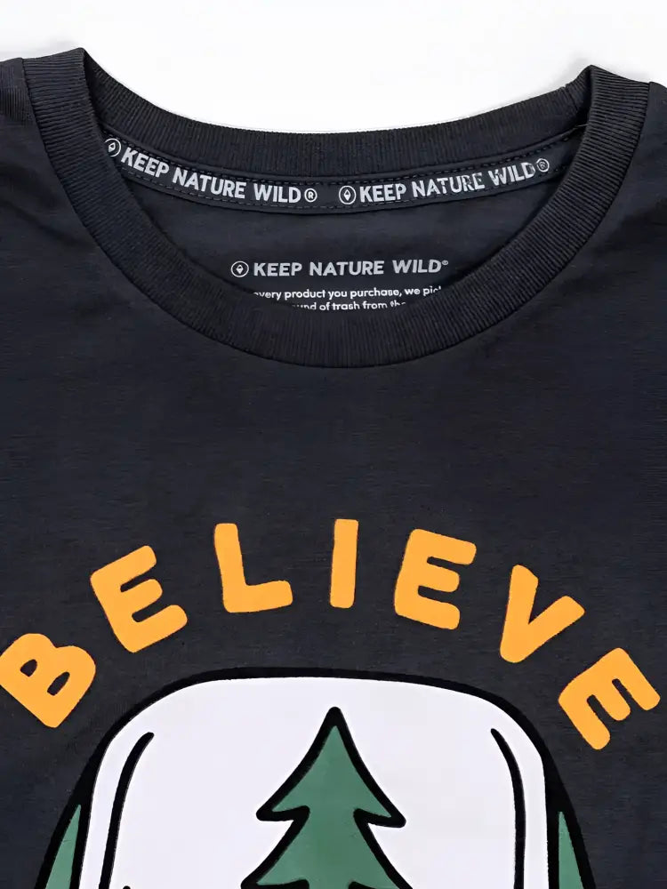 Close up of a black t-shirt with the words Keep Nature Wild on the collar and Believe on the chest