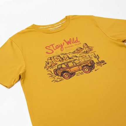 Yellow t-shirt with a graphic of an off-road vehicle in a desert landscape and the text Stay Wild