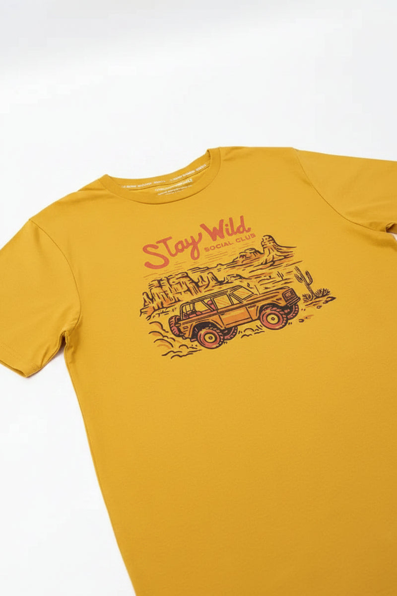 Yellow t-shirt with a graphic of an off-road vehicle in a desert landscape and the text Stay Wild