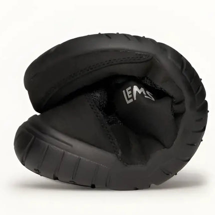Black Lems shoe folded in half to show flexibility