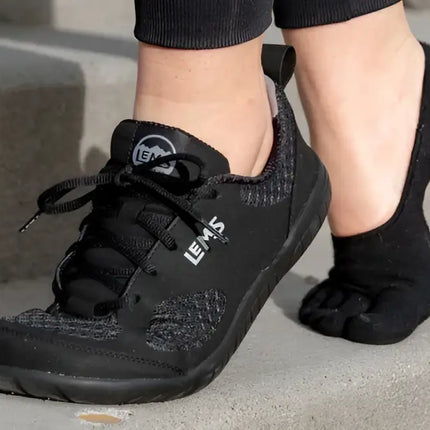 Black Lems Primal Zen shoe on a foot with a black toe sock