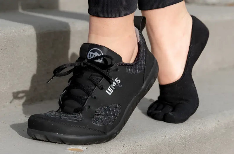 Black Lems Primal Zen shoe on a foot with a black toe sock