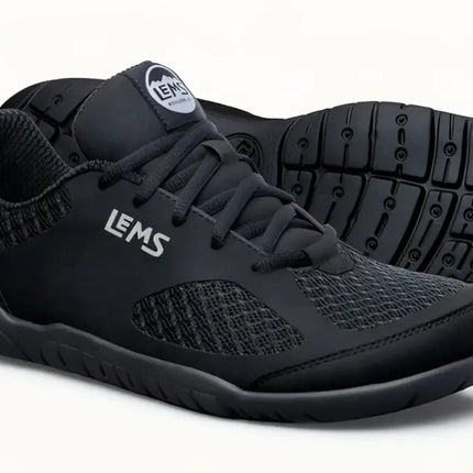 Pair of black Lems Primal Pursuit shoes with textured mesh and solid black accents