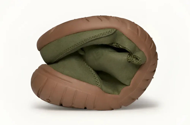 Flexible green shoe with brown sole bent in half