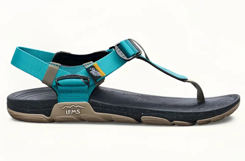Teal and black Lems Primal Pursuit sandal with a tan sole and speckled black footbed