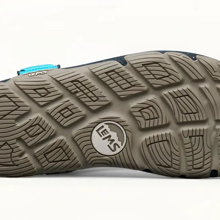 Underside of a Lems Primal Pursuit shoe, showing the textured brown sole with the Lems logo