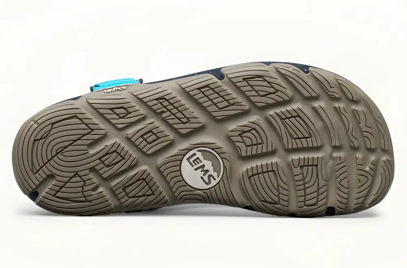 Underside of a Lems Primal Pursuit shoe, showing the textured brown sole with the Lems logo