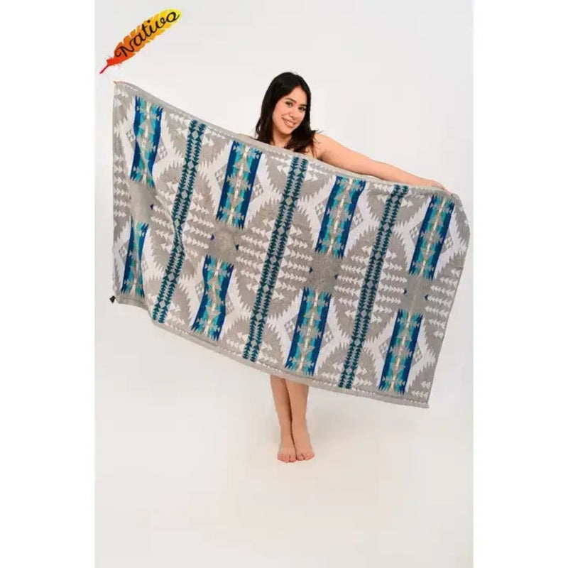 Woman holding a gray, white, and blue patterned blanket