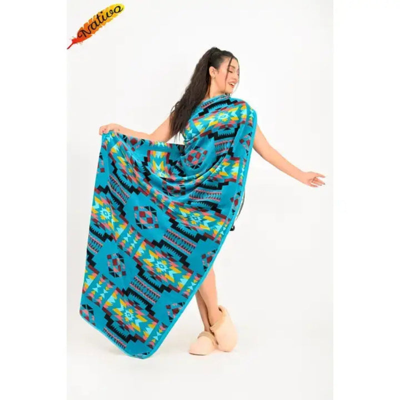 Woman holding up a blue blanket with a geometric pattern in red, yellow, and black