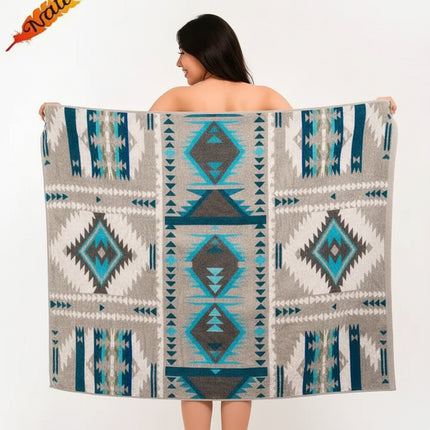 Woman holding up a gray blanket with blue and teal geometric patterns