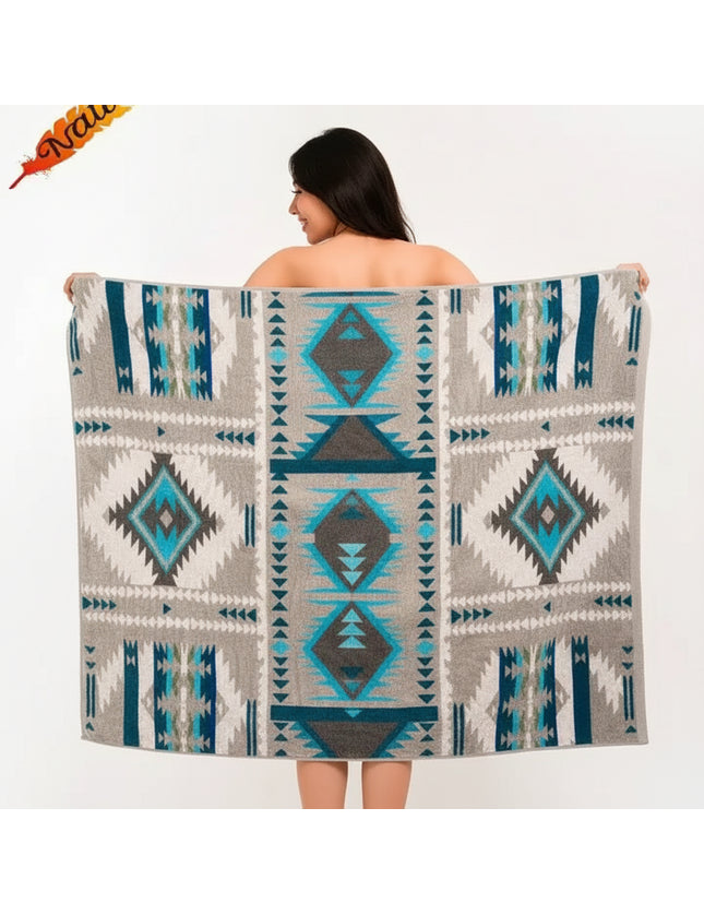 Woman holding up a gray blanket with blue and teal geometric patterns