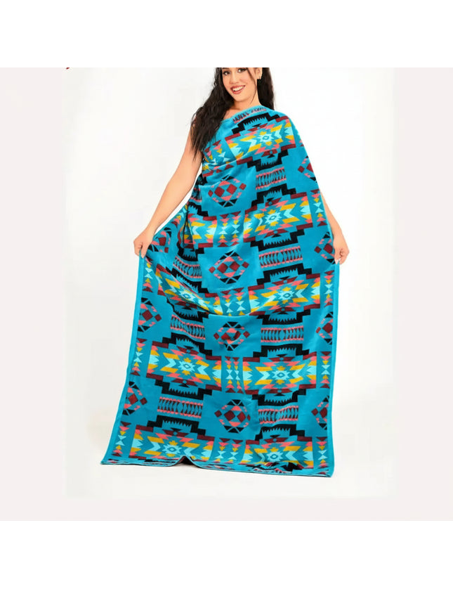 Woman holding up a large blue blanket with a colorful geometric pattern
