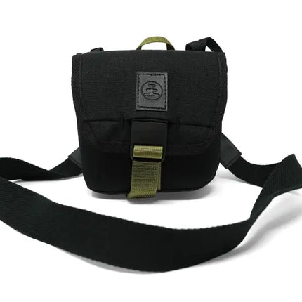 Black camera bag with a green strap and buckle, on a white background