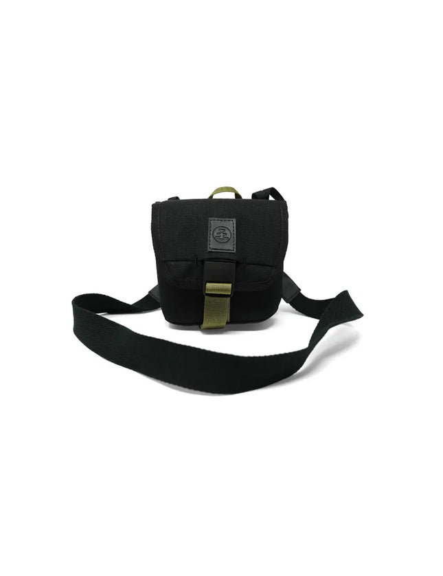Black camera bag with a green strap and buckle, on a white background