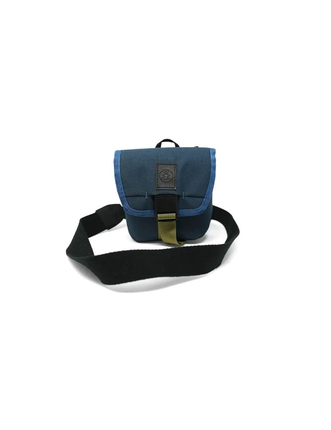 Blue camera bag with a black strap and olive green buckle on a white background