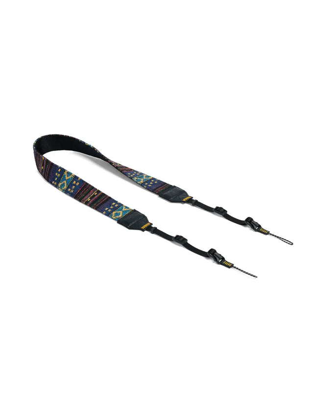Blue and yellow patterned camera strap with black leather accents and adjustable buckles